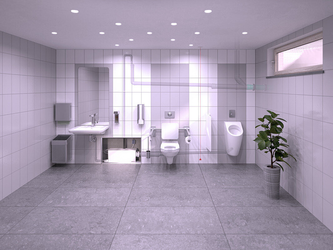 Immagine di un bagno pubblico situato nel seminterrato, in cui un lavabo, un orinatoio e un WC sono collegati alla Piccola stazione di sollevamento Minilift L Duo, nascosto in un'installazione a parete.